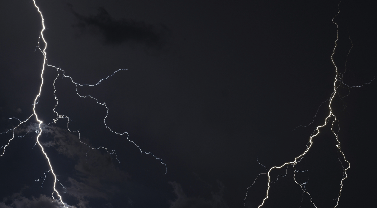 Two lightning strikes in a black sky