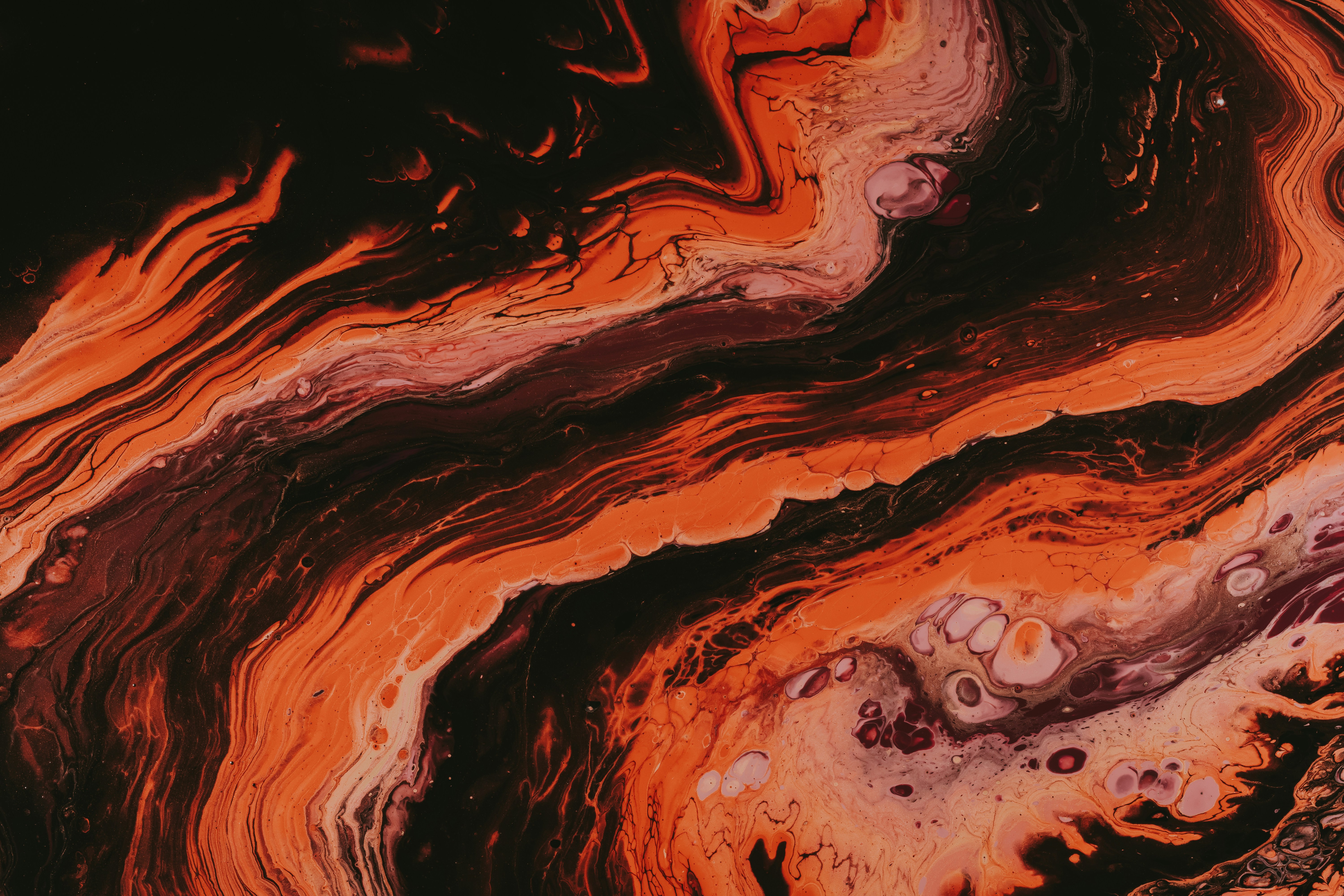 Abstract image with swirling orange, red, and black patterns.