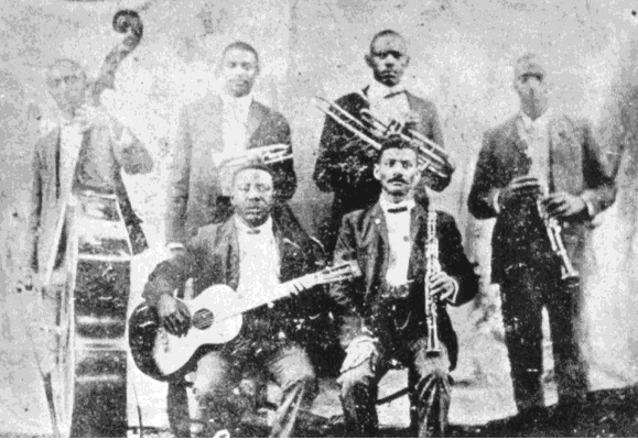 A vintage black-and-white photo of a six-member band with various musical instruments.