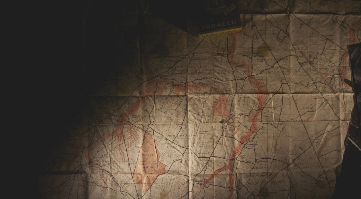 An old map with visible folds and shadows, partially covered by a tobacco box in the corner.